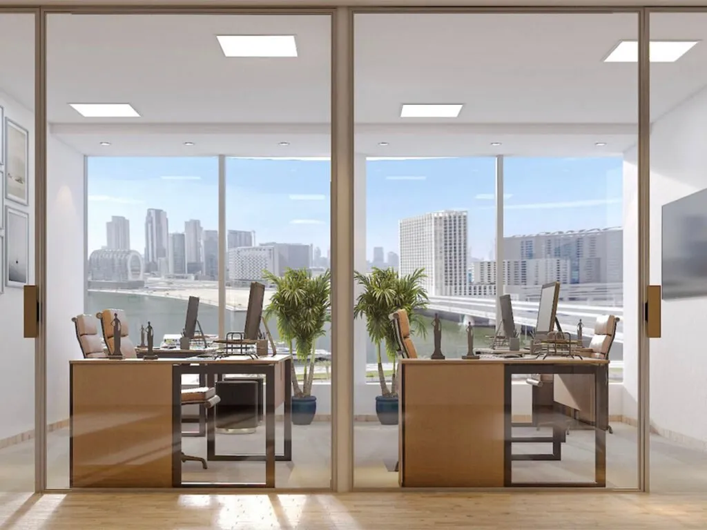 Glass-walled office with city views, plants, and sleek furniture.