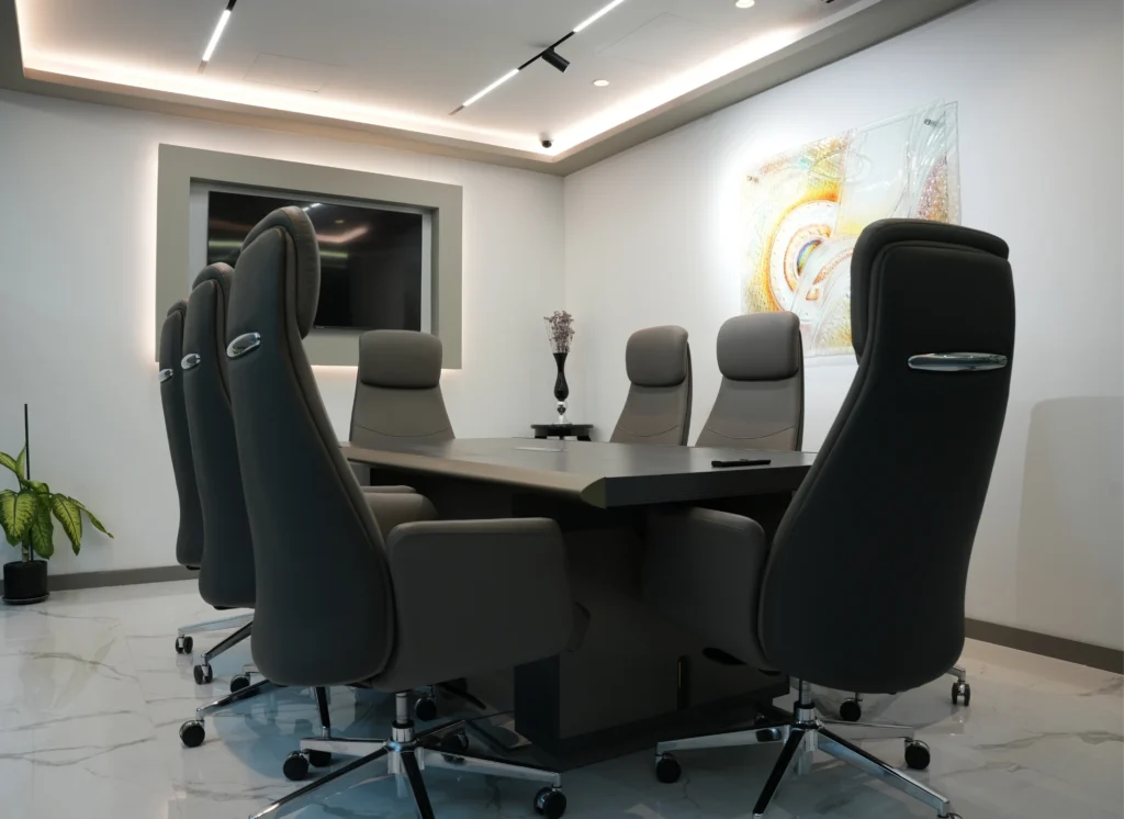 Modern meeting room with dark table and tall grey chairs.