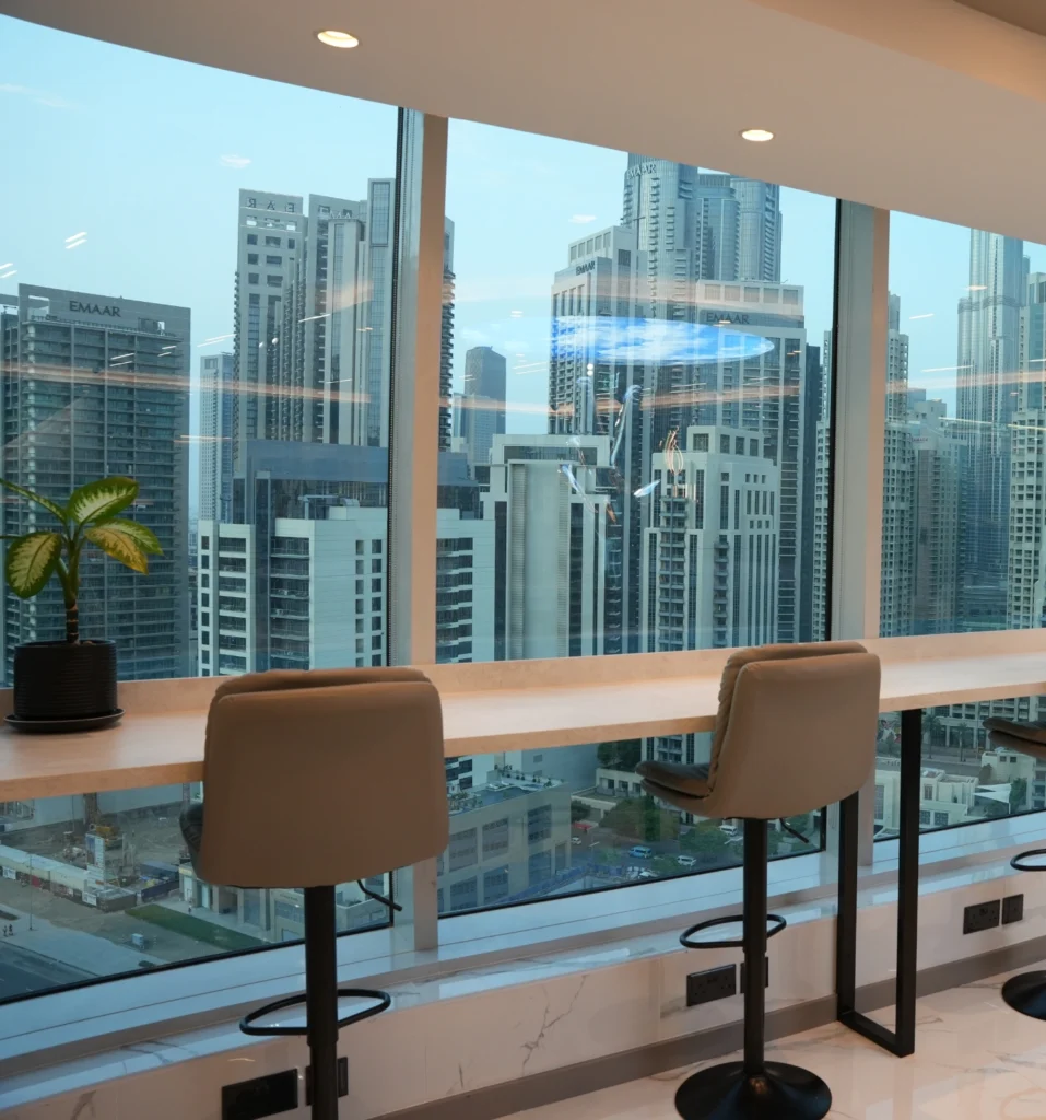Office view of waterfront, park, and city buildings under construction.