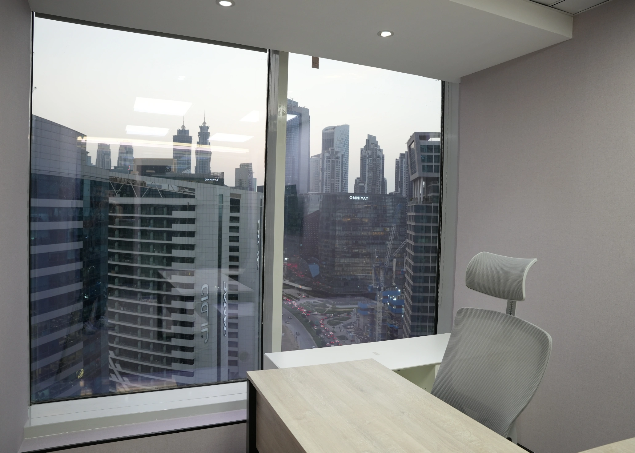 Empty corner office with a large window and city skyline view.