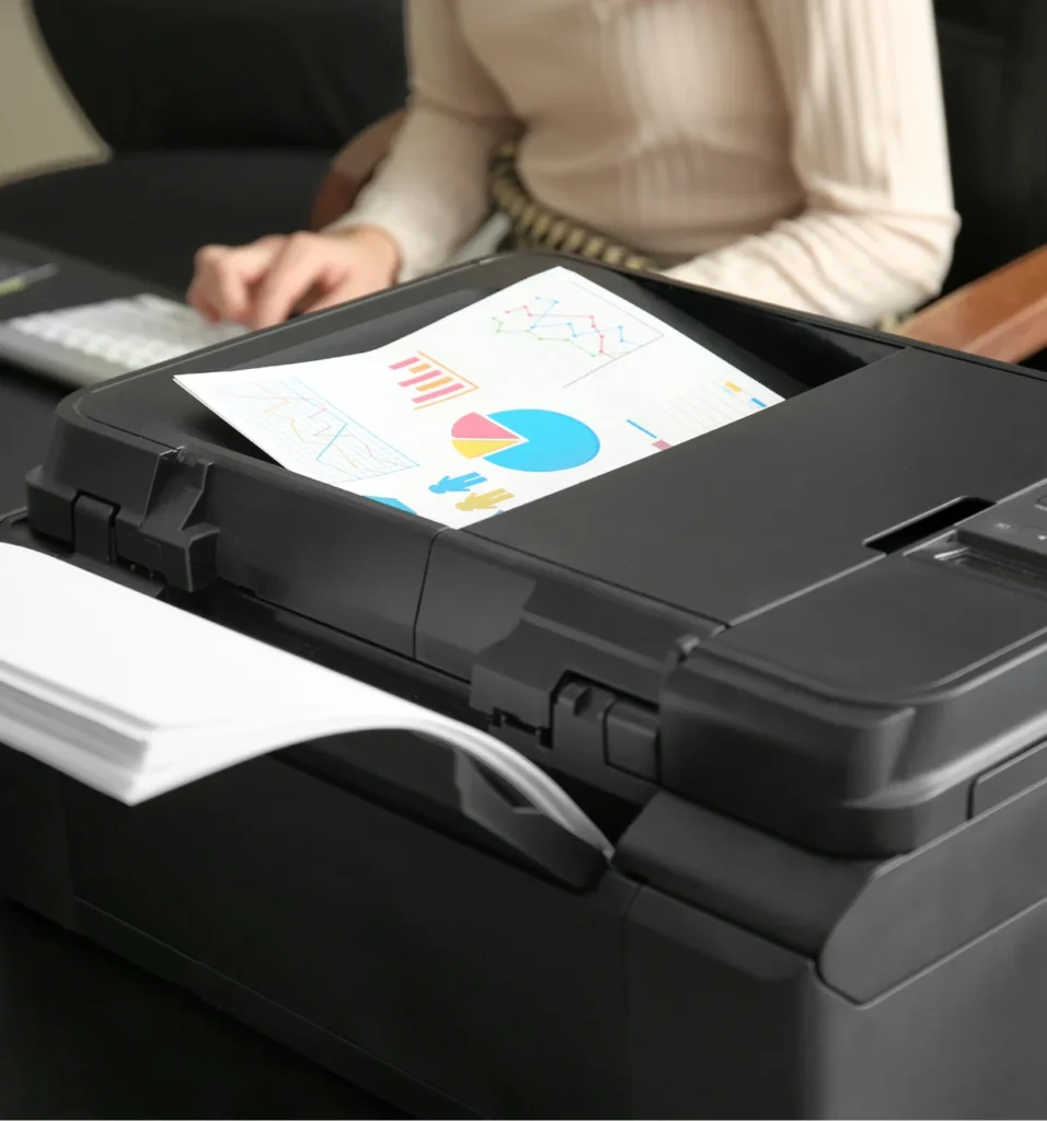 Close-up of an office printer finishing a page containing business analytics and charts.